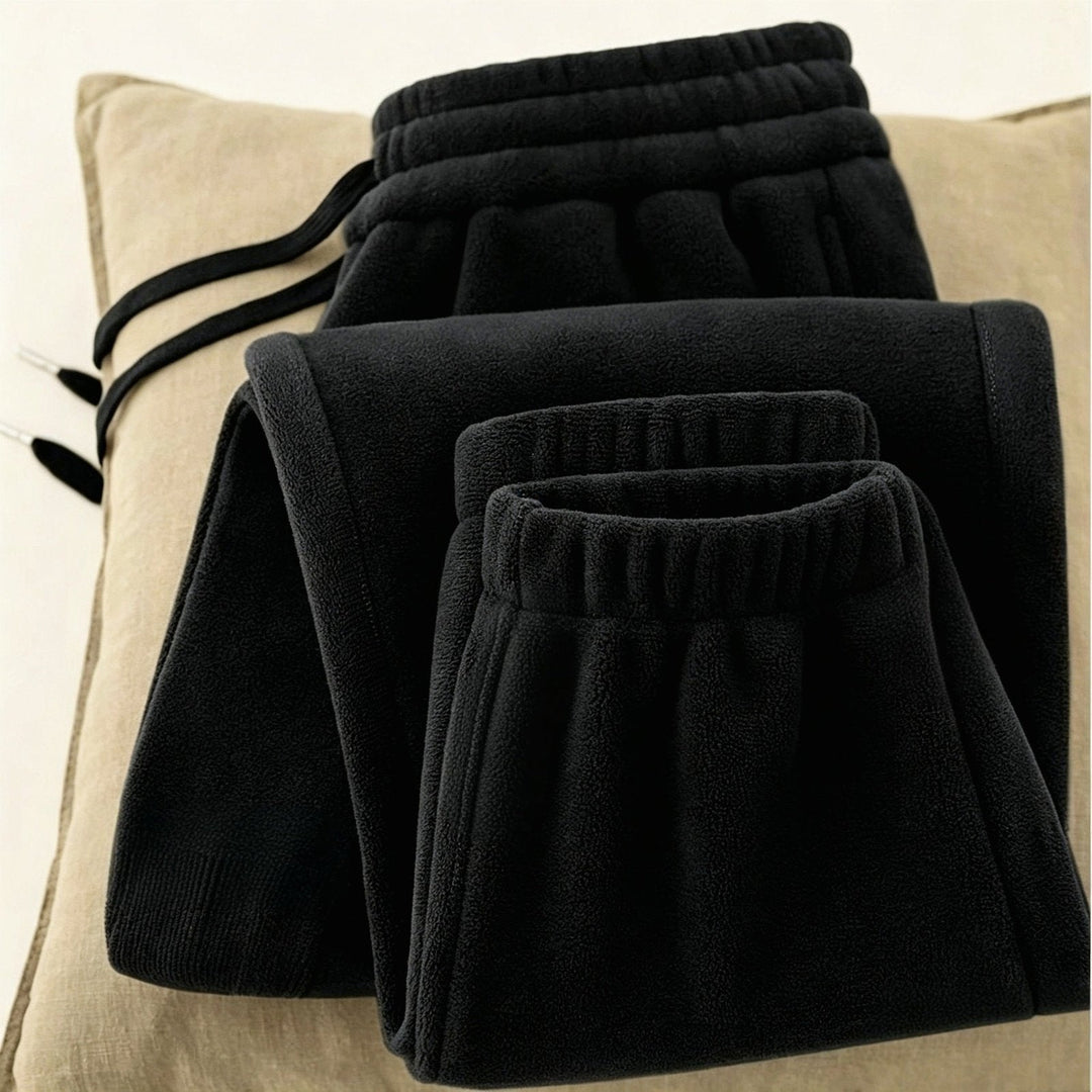Black Soft Fleece Pants folded on a cushion