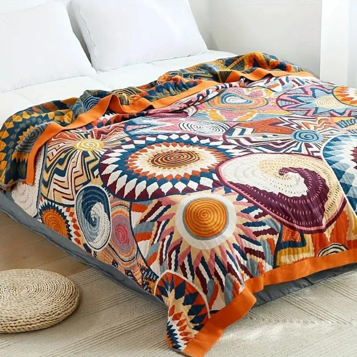 Sunburst Medallion Cotton Throw draped across a bed