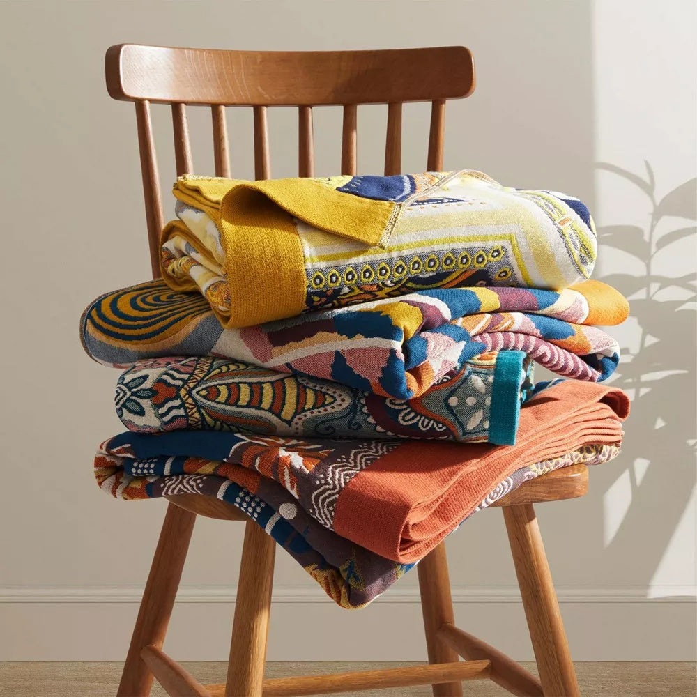 Sunburst Medallion Cotton Throw folded on a wooden chair