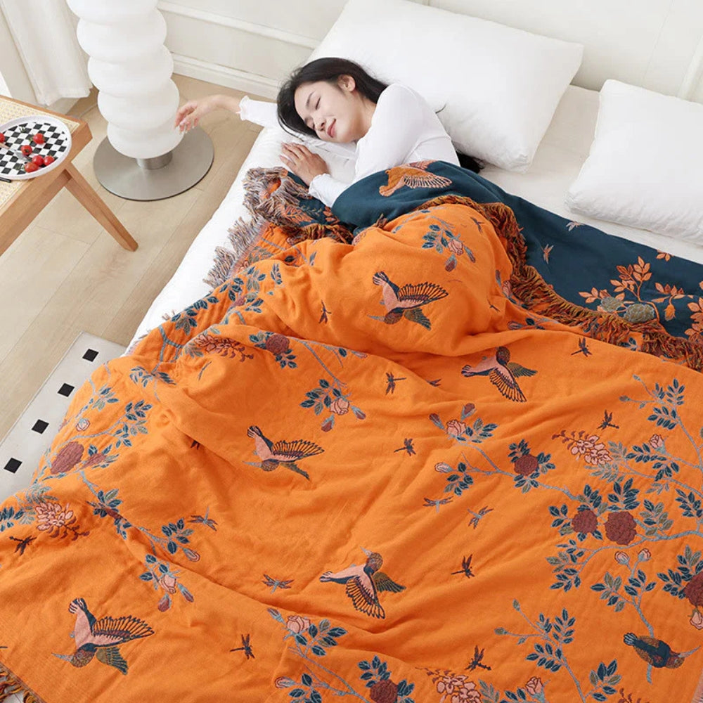 Dark Blue and Orange Ornamental Gauze Cotton Throw on a bed