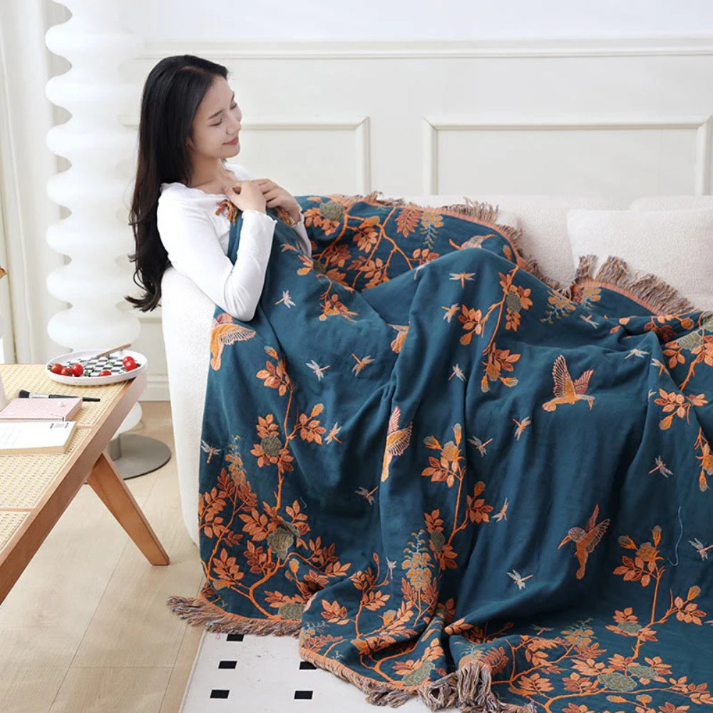 Dark Blue and Orange Ornamental Gauze Cotton Throw wrapped around a seated model