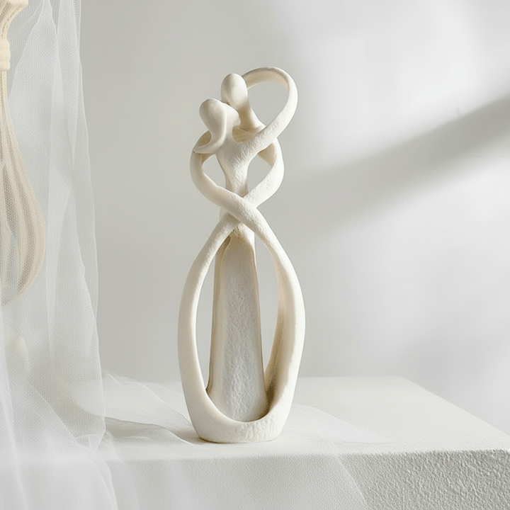 White Textured Ceramic Couple Sculpture close-up by sheer curtain