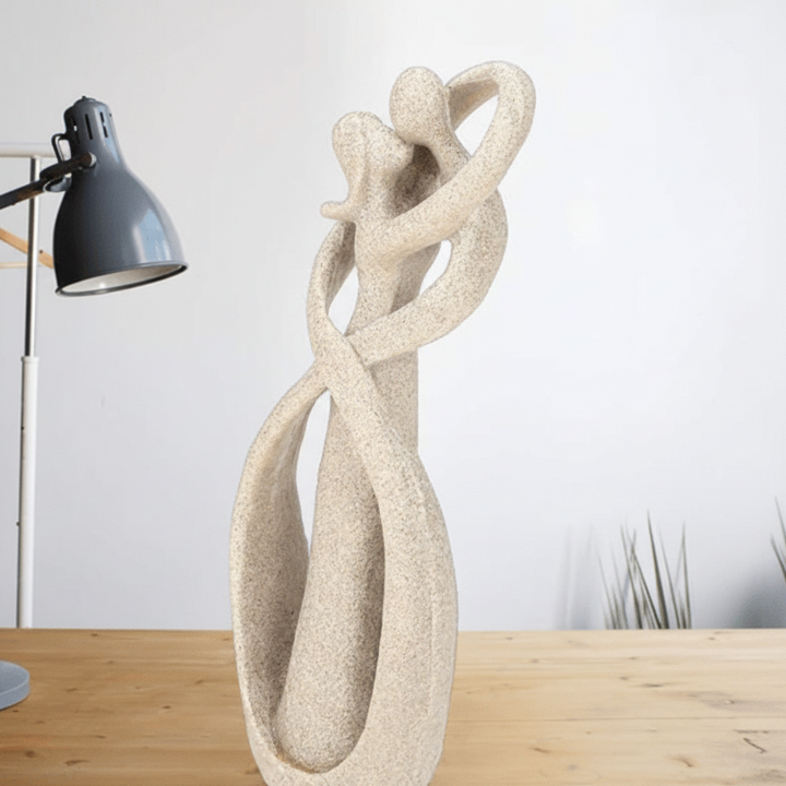 Sand Textured Ceramic Couple Sculpture on wood table near lamp