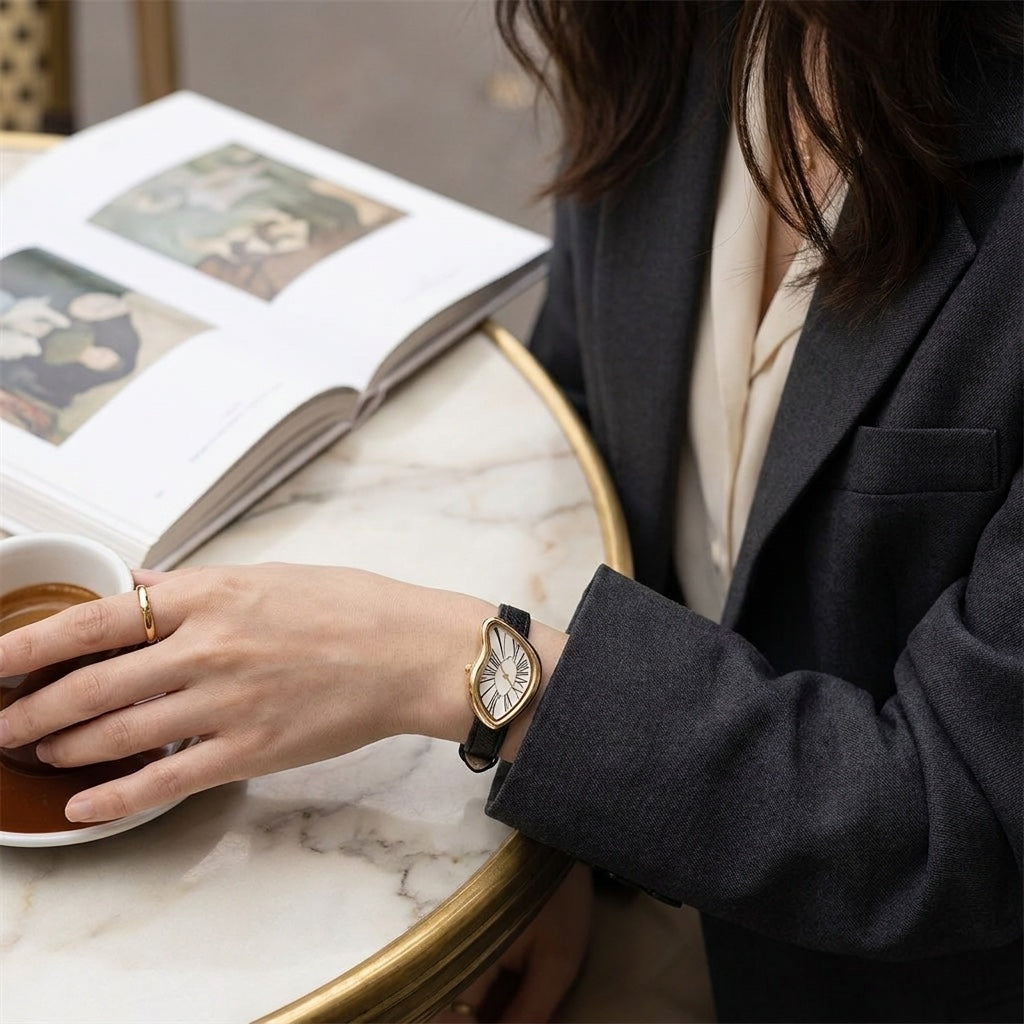 Twisted Gold-Tone Watch with white dial worn at cafe table