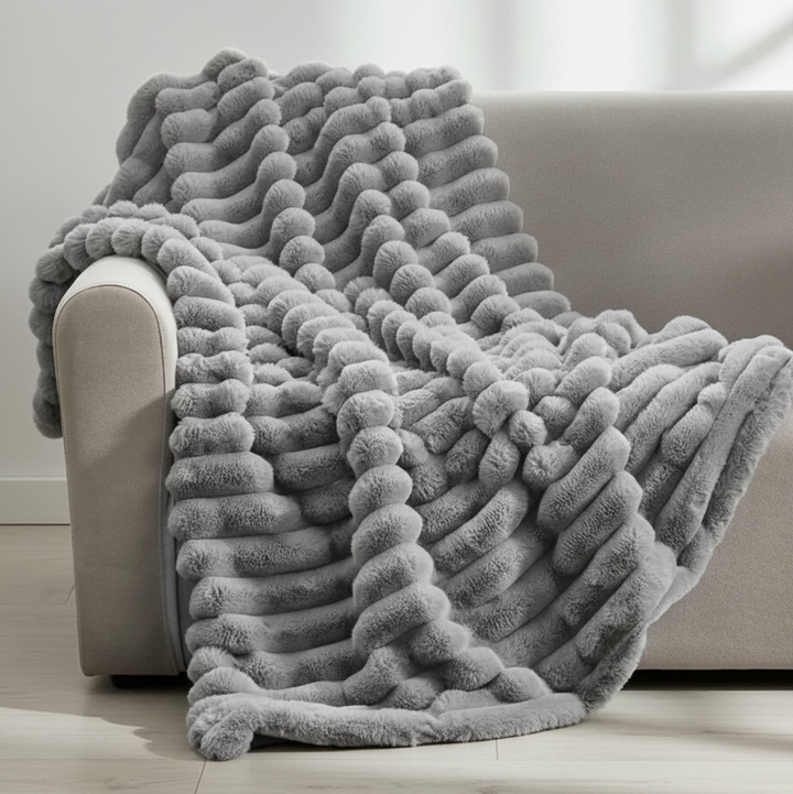 Gray velvety microfleece throw blanket draped over a sofa