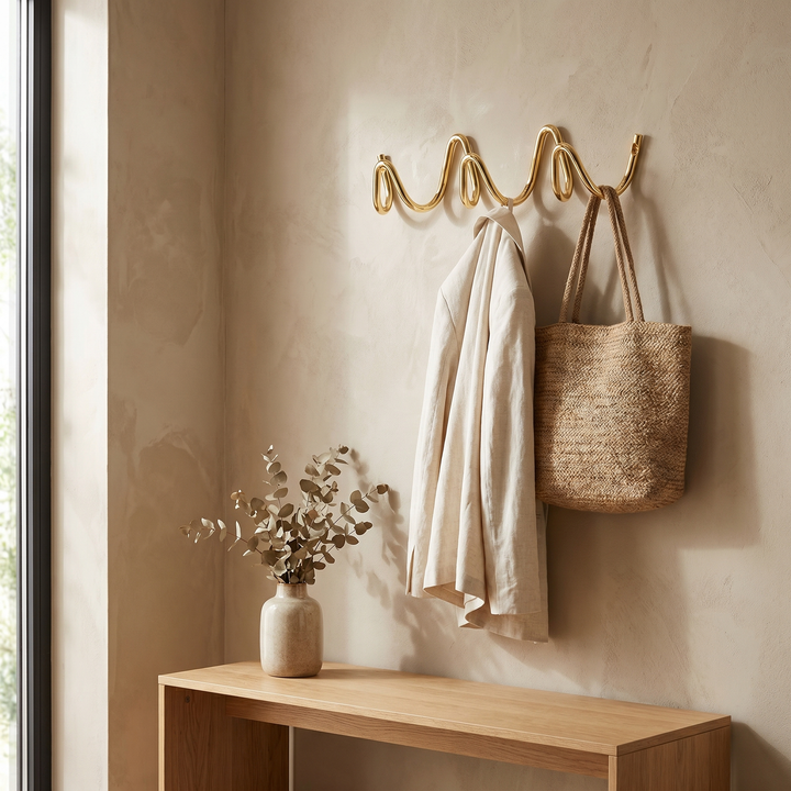 Gold Wavy Iron Wall Coat Hooks in entryway with coat and bag
